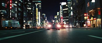 Movie still from “Jumper” (2008), directed by Doug Liman – Cars driving down a street at night in a city; Extreme Wide shot, High angle