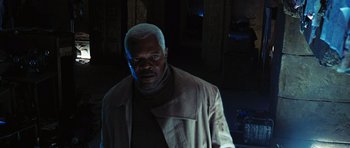 Movie still from “Jumper” (2008), directed by Doug Liman – A man in a brown jacket standing in a dark room; Close Up shot, Low angle