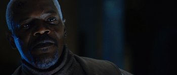 Movie still from “Jumper” (2008), directed by Doug Liman – An older man with a white beard is smiling for the camera; Close Up shot, Over the shoulder angle