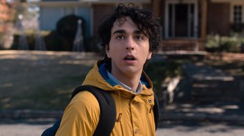 Movie still from “Jumanji: Welcome to the Jungle” (2017), directed by Jake Kasdan – A young man in a yellow raincoat with a backpack; Close Up shot, Over the shoulder angle