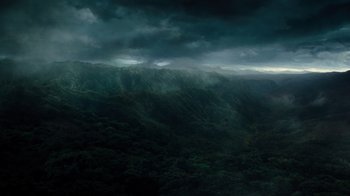 Movie still from “Jumanji: Welcome to the Jungle” (2017), directed by Jake Kasdan – A view of a mountain range with dark clouds in the background; Extreme Wide shot, High angle