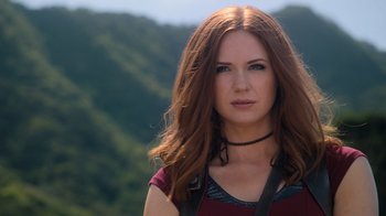 Movie still from “Jumanji: Welcome to the Jungle” (2017), directed by Jake Kasdan – A woman with long red hair wearing a red shirt; Close Up shot, Low angle