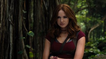 Movie still from “Jumanji: Welcome to the Jungle” (2017), directed by Jake Kasdan – A beautiful young woman with red hair wearing a red shirt; Medium shot, Over the shoulder angle