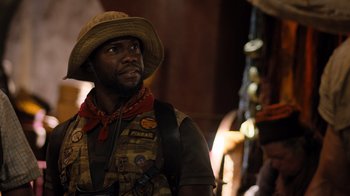 Movie still from “Jumanji: Welcome to the Jungle” (2017), directed by Jake Kasdan – A man in a cowboy hat looking to his left; Close Up shot, Over the shoulder angle