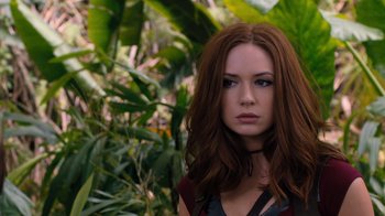 Movie still from “Jumanji: Welcome to the Jungle” (2017), directed by Jake Kasdan – A woman with long red hair standing next to a tree; Close Up shot, Over the shoulder angle