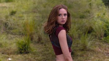 Movie still from “Jumanji: Welcome to the Jungle” (2017), directed by Jake Kasdan – A beautiful young lady standing in the grass; Medium shot, Over the shoulder angle