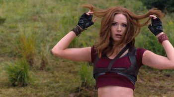 Movie still from “Jumanji: Welcome to the Jungle” (2017), directed by Jake Kasdan – A beautiful young woman with long , red , brown and red hair; Medium shot, Over the shoulder angle