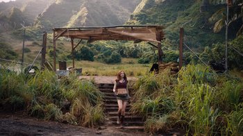 Movie still from “Jumanji: Welcome to the Jungle” (2017), directed by Jake Kasdan – A woman walking up some steps in a field; Wide shot, High angle