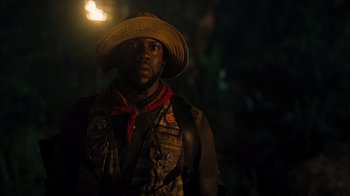 Movie still from “Jumanji: Welcome to the Jungle” (2017), directed by Jake Kasdan – A man wearing a straw hat standing in the dark; Close Up shot, Low angle