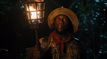 Movie still from “Jumanji: Welcome to the Jungle” (2017), directed by Jake Kasdan – A man holding a lantern in the dark at night; Close Up shot, Over the shoulder angle