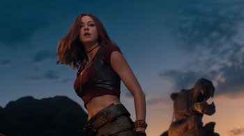 Movie still from “Jumanji: Welcome to the Jungle” (2017), directed by Jake Kasdan – A woman with long red hair wearing a red shirt; Medium shot, Low angle