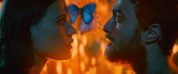 Movie still from “Jungle” (2017), directed by Greg McLean – A man and a woman face to face with a blue butterfly flying in the background; Extreme Close Up shot, Over the shoulder angle