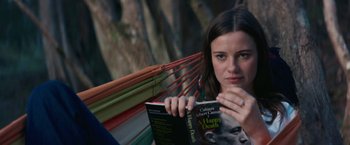 Movie still from “Jungle” (2017), directed by Greg McLean – A woman sitting in a hammock reading a book; Close Up shot, Over the shoulder angle