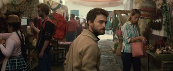 Movie still from “Jungle” (2017), directed by Greg McLean – A man standing in the middle of an outdoor market; Medium shot, Over the shoulder angle
