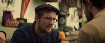 Movie still from “Jungle” (2017), directed by Greg McLean – A man with glasses holding a popsicle in his hand; Close Up shot, Over the shoulder angle