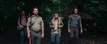 Movie still from “Jungle” (2017), directed by Greg McLean – A group of men standing next to each other in the woods; Medium shot, Over the shoulder angle