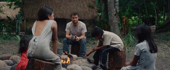 Movie still from “Jungle” (2017), directed by Greg McLean – A group of people sitting around a fire pit; Medium shot, Over the shoulder angle