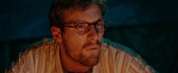 Movie still from “Jungle” (2017), directed by Greg McLean – A person wearing glasses; Close Up shot, Low angle