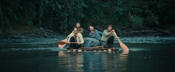 Movie still from “Jungle” (2017), directed by Greg McLean – A group of men on a raft on a river; Wide shot, High angle