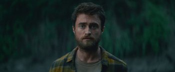 Movie still from “Jungle” (2017), directed by Greg McLean – A person with a beard looking at the camera; Close Up shot, Over the shoulder angle