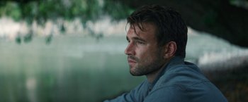 Movie still from “Jungle” (2017), directed by Greg McLean – A person looking out a window; Close Up shot, Low angle