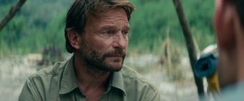Movie still from “Jungle” (2017), directed by Greg McLean – A person wearing a shirt; Close Up shot, Over the shoulder angle
