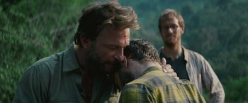 Movie still from “Jungle” (2017), directed by Greg McLean – Two men kissing each other while another man watches; Close Up shot, Over the shoulder angle