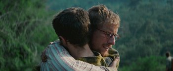 Movie still from “Jungle” (2017), directed by Greg McLean – A couple of men hugging each other on top of a hill; Close Up shot, Over the shoulder angle
