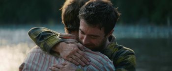 Movie still from “Jungle” (2017), directed by Greg McLean – A man hugging another man with his arms wrapped around him; Close Up shot, Over the shoulder angle
