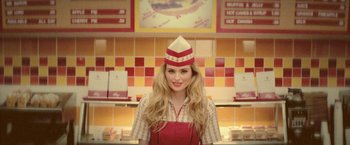 Movie still from “Jungle” (2017), directed by Greg McLean – A woman wearing a red apron and a red hat; Medium shot, Low angle