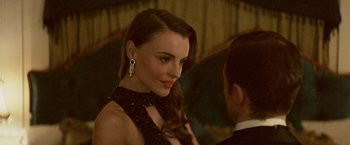 Movie still from “Jungle” (2017), directed by Greg McLean – A beautiful woman in a black dress and a man in a suit; Close Up shot, Over the shoulder angle