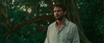 Movie still from “Jungle” (2017), directed by Greg McLean – A person standing near a tree; Close Up shot, Low angle