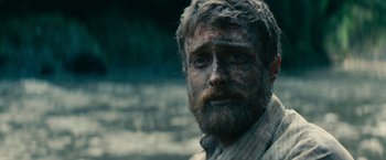 Movie still from “Jungle” (2017), directed by Greg McLean – A person with mud on his face; Close Up shot, Over the shoulder angle