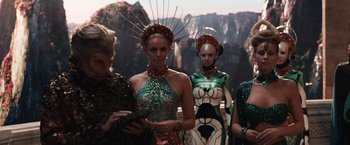 Movie still from “Jupiter Ascending” (2015), directed by Lilly Wachowski – A group of women in costumes standing next to each other; Medium shot, Low angle