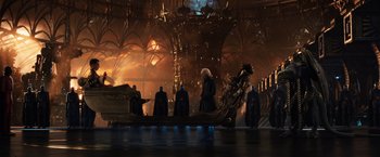 Movie still from “Jupiter Ascending” (2015), directed by Lilly Wachowski – A group of people standing around a building with lights on it; Wide shot, High angle