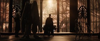 Movie still from “Jupiter Ascending” (2015), directed by Lilly Wachowski – A man sitting on top of a bench in front of a window; Wide shot, Low angle