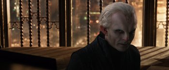 Movie still from “Jupiter Ascending” (2015), directed by Lilly Wachowski – A man with white hair is looking at the camera; Close Up shot, Over the shoulder angle