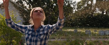 Movie still from “Jupiter Ascending” (2015), directed by Lilly Wachowski – A woman in a blue and white plaid shirt holding a frisbee; Medium shot, Low angle