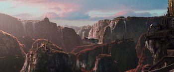 Movie still from “Jupiter Ascending” (2015), directed by Lilly Wachowski – An airplane flying over a mountain with a sky in the background; Extreme Wide shot, High angle