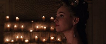 Movie still from “Jupiter Ascending” (2015), directed by Lilly Wachowski – A woman in a dress looking to her left; Close Up shot, Over the shoulder angle