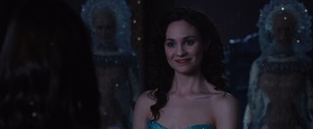 Movie still from “Jupiter Ascending” (2015), directed by Lilly Wachowski – A woman in a strapless blue dress posing for a picture; Close Up shot, Over the shoulder angle
