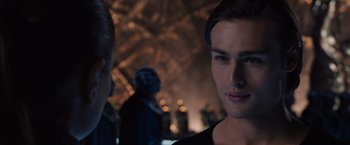 Movie still from “Jupiter Ascending” (2015), directed by Lilly Wachowski – A man in a black shirt is looking at the camera; Close Up shot, Over the shoulder angle