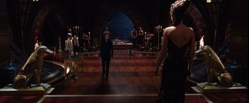 Movie still from “Jupiter Ascending” (2015), directed by Lilly Wachowski – A group of people standing around in a room; Wide shot, Over the shoulder angle