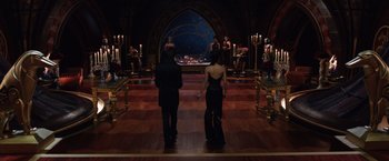 Movie still from “Jupiter Ascending” (2015), directed by Lilly Wachowski – Two people standing in front of candles in a dark room; Wide shot, High angle
