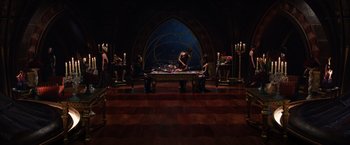 Movie still from “Jupiter Ascending” (2015), directed by Lilly Wachowski – A group of people sitting around a table in front of candles; Wide shot, High angle