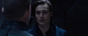 Movie still from “Jupiter Ascending” (2015), directed by Lilly Wachowski – A man with long dark hair is looking at another man; Close Up shot, Over the shoulder angle