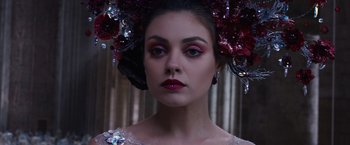 Movie still from “Jupiter Ascending” (2015), directed by Lilly Wachowski – A woman wearing a dress and a crown of flowers; Close Up shot, Over the shoulder angle