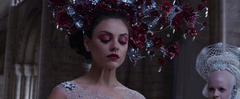 Movie still from “Jupiter Ascending” (2015), directed by Lilly Wachowski – A woman wearing a dress and a floral headpiece; Close Up shot, Over the shoulder angle