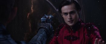 Movie still from “Jupiter Ascending” (2015), directed by Lilly Wachowski – A man in a red jacket is holding a gun in his hand; Close Up shot, Over the shoulder angle