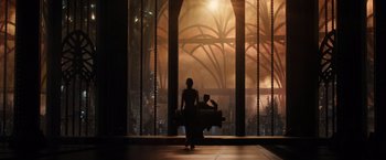 Movie still from “Jupiter Ascending” (2015), directed by Lilly Wachowski – A person standing in front of a large window; Wide shot, Low angle
